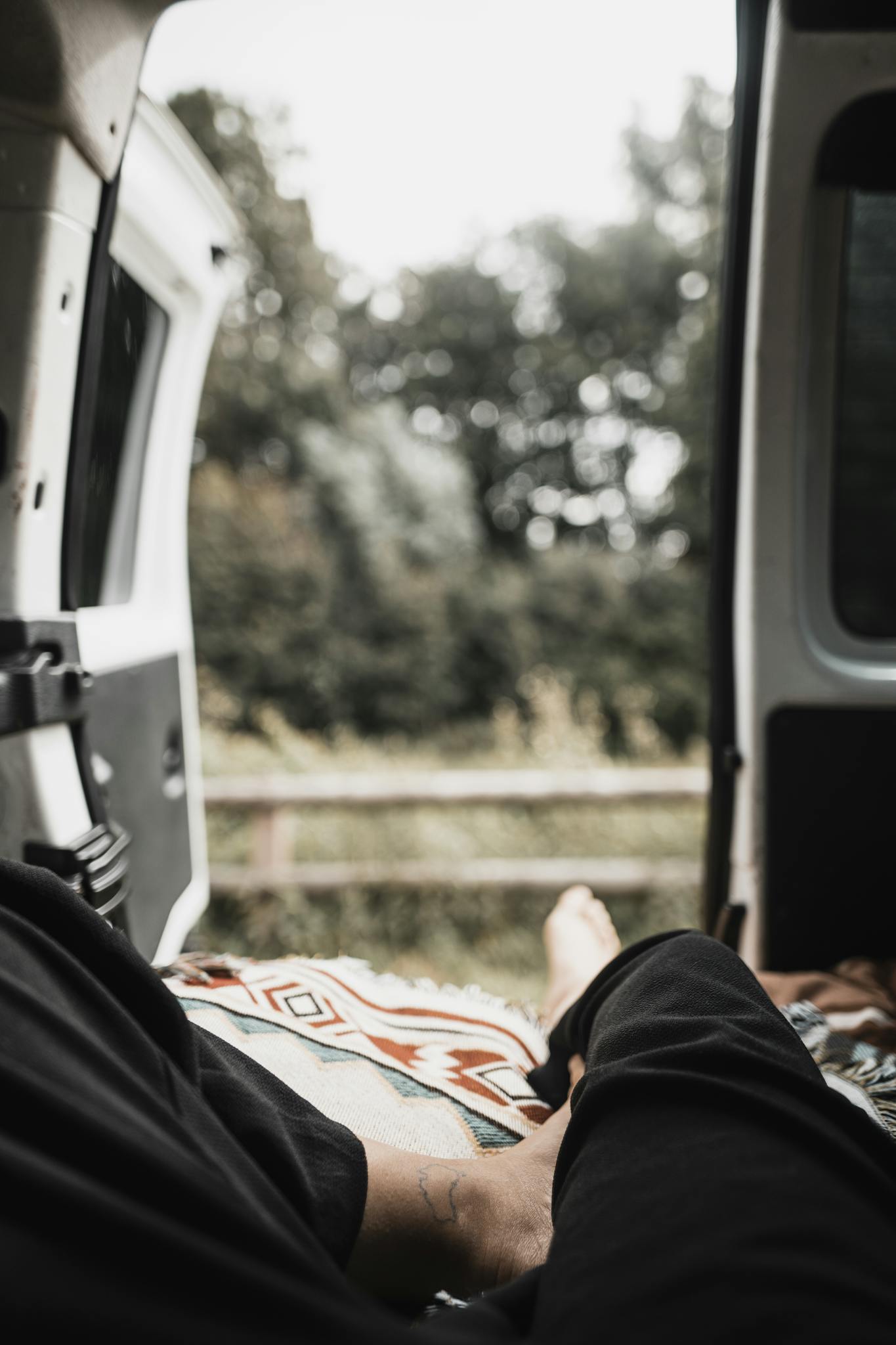Person relaxing in van, enjoying the outdoor scenery. Perfect for travel and adventure themes.