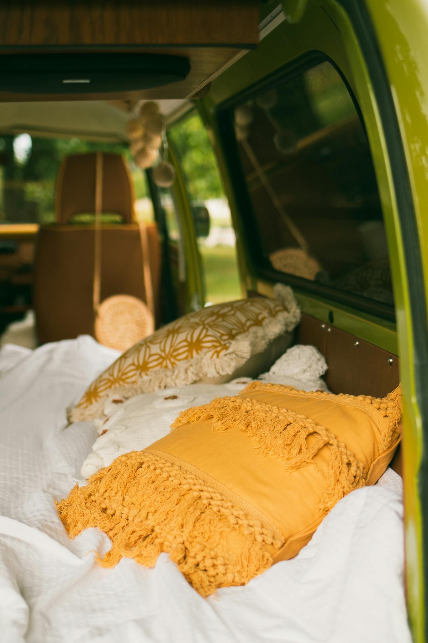 Warm and inviting van interior featuring colorful pillows and bedding in a travel-ready setting.